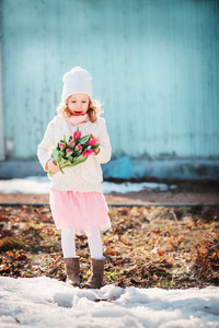 儿童女孩与郁金香花束在春天天一早步行