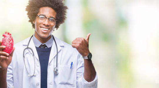 美国黑人心脏病医生的人在孤立的背景指向和显示拇指向上的一面微笑着快乐的脸