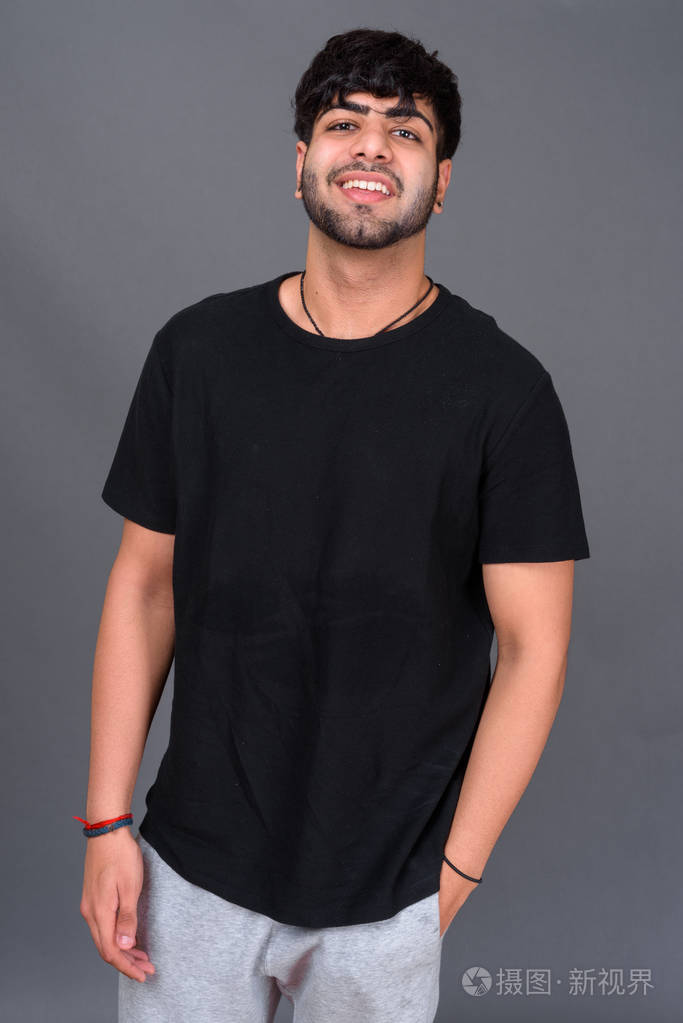 年轻英俊的印度男人在灰色背景
