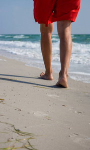 夏日沙滩上 年轻人放松休闲 脚踩细沙感受海洋美容