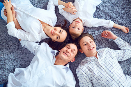 幸福的家庭微笑着躺在地板上