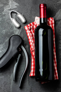 一瓶红酒与 corksrew 和意大利餐巾在石板背景。顶部视图