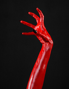 红魔鬼手,红色的手的撒旦,万圣节主题,黑色背景,孤立照片