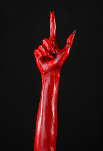 黑色背景,孤立愤怒的撒旦红色的撒旦手做重金属或撒旦的手势女孩的