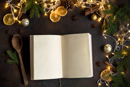 黑暗桌子上的圣诞食谱或菜单。空的烹饪书, 食谱书与节日圣诞节装饰和香料