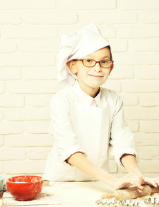年轻男孩在华美背景的厨房制作蛋糕