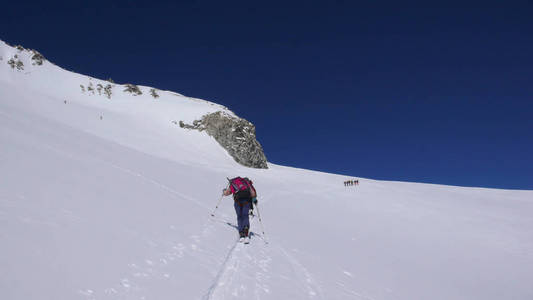 在一个美丽的冬日里, 几个乡村滑雪者徒步, 爬到瑞士一个偏远的山峰