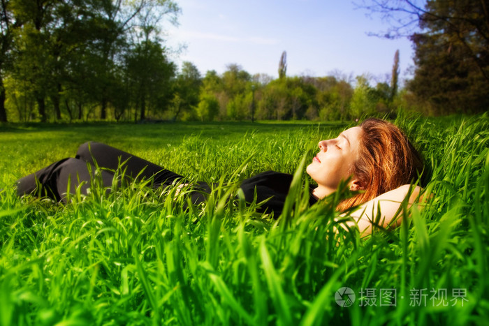 无忧无虑的概念 —— 女人放松户外在草丛中