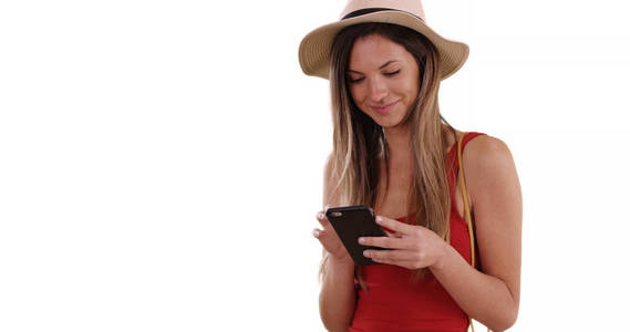 快乐的千禧年妇女在帽子和坦克顶部使用手机应用程序在白色的拷贝空间