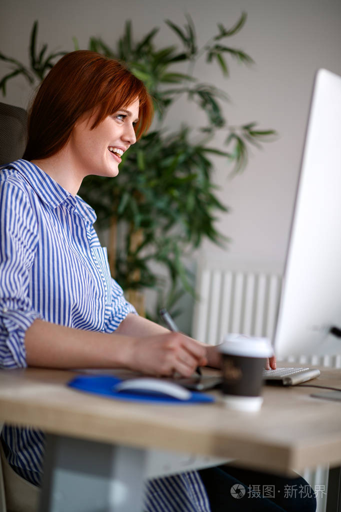 年轻女性在办公室的书桌上