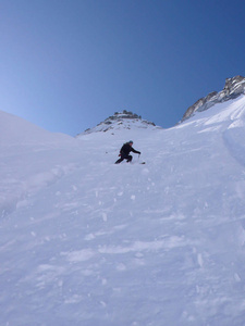 极端滑雪者滑雪一个非常陡峭的北脸滑雪下降在瑞士的阿尔卑斯山