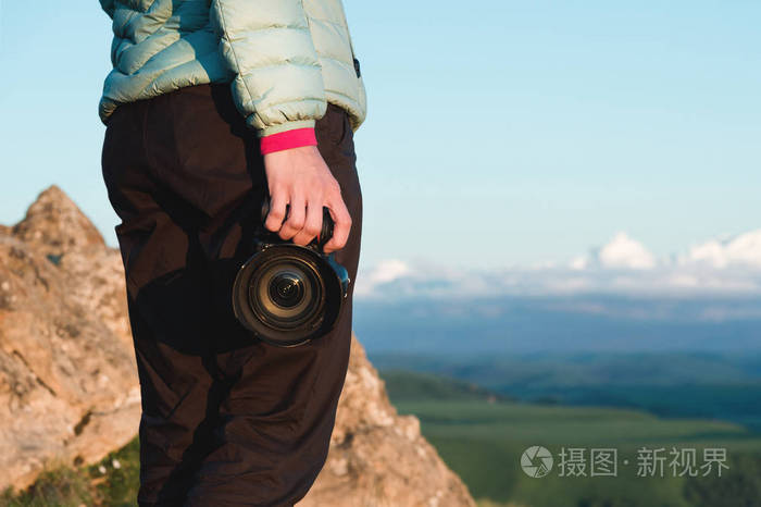 特写单反相机的手里的女孩摄影师的手里的相机侧面视图