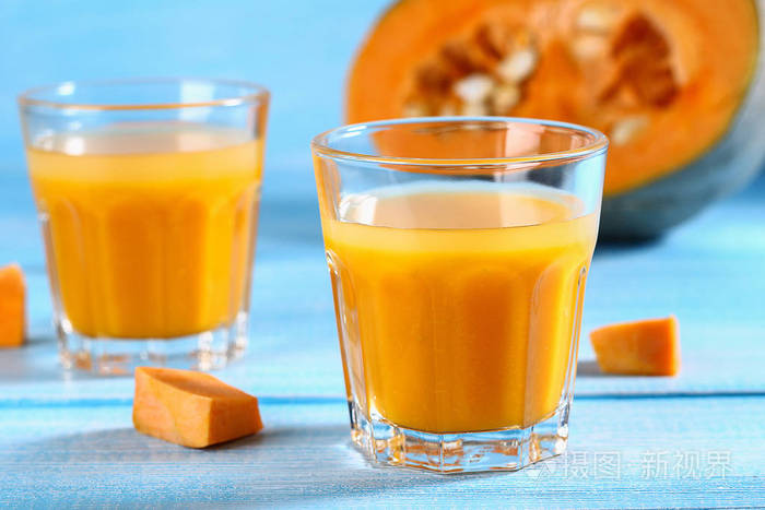 南瓜冰沙杯在蓝色桌子上的南瓜汁秋季饮料