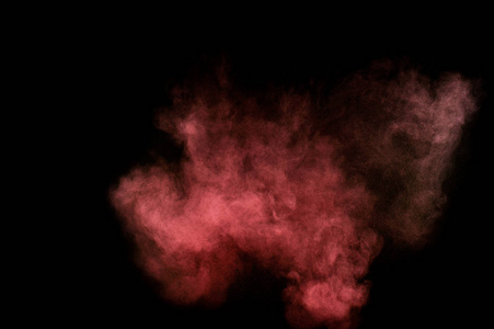 在黑色背景上的红色和粉红色粉末爆炸。彩色的粉末云。多彩的粉尘爆炸。油漆洒红节