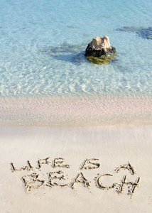 生命是用背景热带海浪在白色沙滩上编写的海滩消息