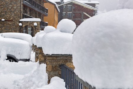 围栏, 石柱和汽车下大雪堆雪。石城市大厦在距离。多云的天气, 大雪