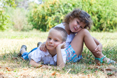 小男孩和女孩在一起躺在草地上