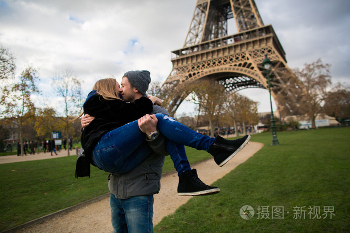 快乐微笑情侣接吻在巴黎埃菲尔铁塔