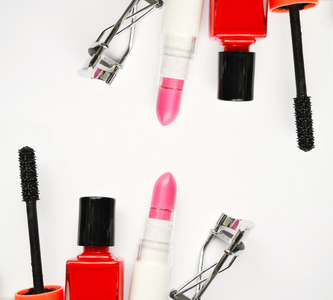 化妆品用黑色睫毛膏，粉色和红色指甲油，口红和睫毛上白色孤立的卷发器设置