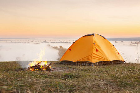 篝火和日出时的帐篷