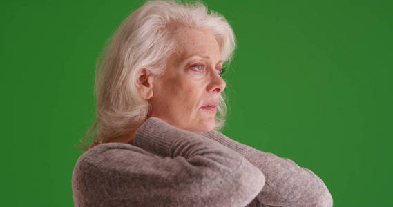 妇女的画像与脖子痛苦摩擦脖子看屏幕在绿色