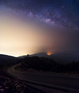 银河银河中的星星和空间尘埃在宇宙和黄道光之上的夜空之上他侬国家公园与道路前景。清迈, 泰国。长时间曝光