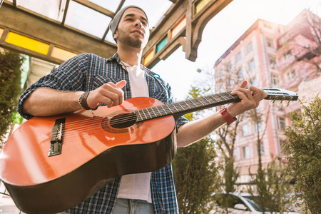 周到的男性吉他手训练在街上玩耍