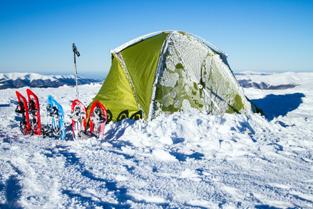 冬山帐篷。帐篷里站在雪地里山。雪是在帐篷旁边