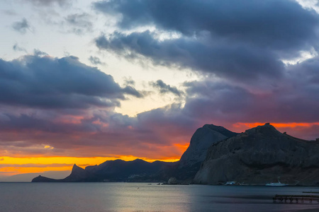 在海湾五颜六色的夕阳。山地背景