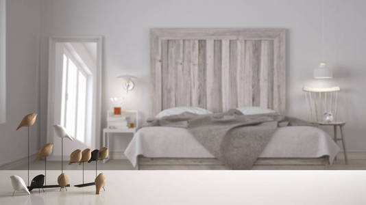 白色桌面或货架与简约的鸟装饰, 鸟的小窍门诀窍在模糊的斯堪的纳维亚卧室与木制床头板, 现代室内设计