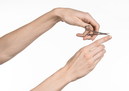 健康和个人护理 手中拿着剪刀为孤立的白色背景上的指甲