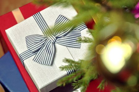 圣诞夜在家里的圣诞树下站在地板上的礼品盒