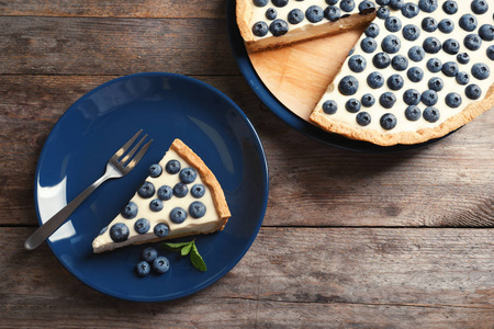 木桌上一块美味的蓝莓蛋糕平躺组合