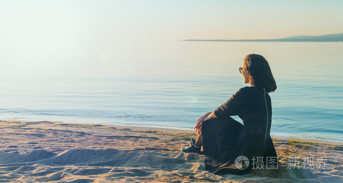 坐在海滩上的衣服的女人
