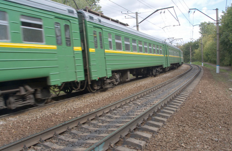 绿色的火车在铁路上快速移动图片
