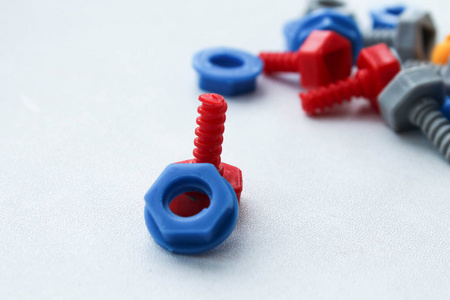 儿童塑料玩具螺栓和螺母在一个孤立的背景