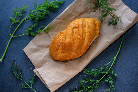 桌上的面包就在炉子上. 从牛皮纸和莳萝叶子的面包仍然生活