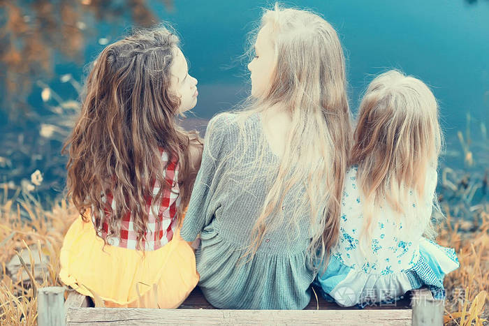 三可爱的小女孩在河岸上.暑假.