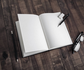 空白书和文具的相片在木背景.用于放置设计的模板照片