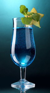 蓝色鸡尾酒在蓝色背景上的玻璃