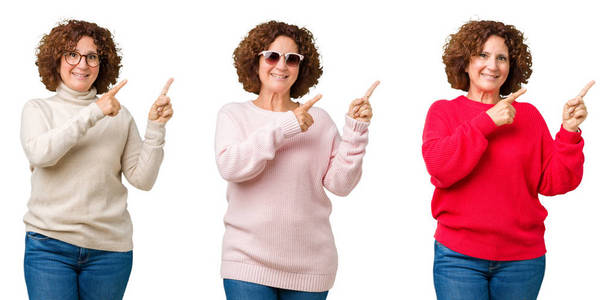 中年老年妇女穿着冬季毛衣在白色孤立的背景微笑着, 看着相机指向镜头, 用两只手和手指指着一边