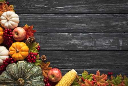 秋枫叶与南瓜和红色浆果在老木后台的顶部视图。感恩节概念