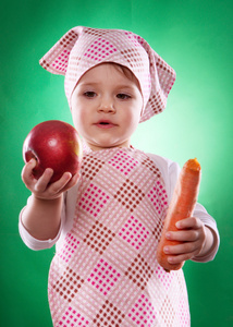 抱着一种孤立的蔬菜方巾和厨房围裙女婴