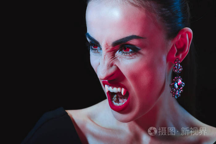 可怕的吸血鬼显示她的獠牙和看着远离孤立的黑色