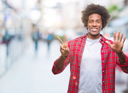 非裔美国男子在孤立的背景显示和指向手指数七, 而微笑着自信和快乐
