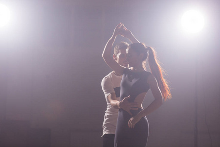 在音乐会的灯光和烟雾下, 熟练的舞者在暗室里表演。感性情侣表演艺术和情感的当代舞蹈
