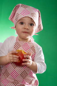 抱着一种孤立的蔬菜方巾和厨房围裙女婴