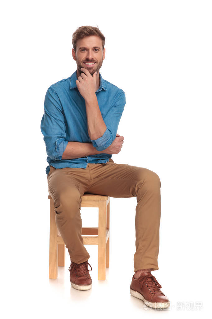 微笑坐着的休闲男人是在思考孤立的白色背景