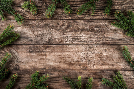 创意布局框架由圣诞冷杉树枝, 松果在木背景。圣诞节和新年主题。平面布局, 顶部视图