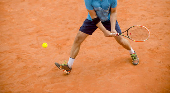男子在户外打网球. 体育比赛中, 网球运动员在球场上拿着球拍和球